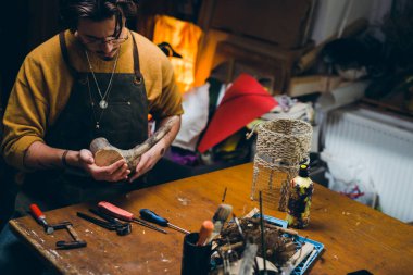 Adam atölyesinde ahşapla çalışıyor.