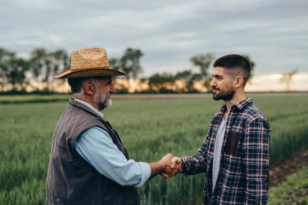 İş adamları dışarıda tokalaşıyor.