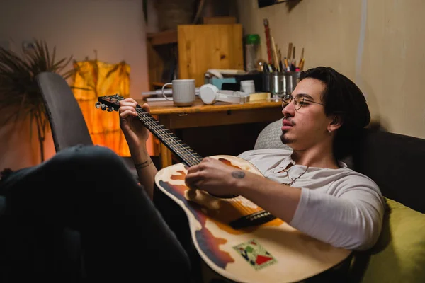 Jovem Sentado Seu Quarto Tocando Guitarra Acústica — Fotografia de Stock