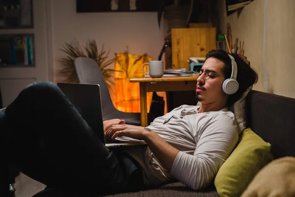 Молодий Чоловік Використовує Ноутбук Сидячи Своїй Кімнаті Він Носить Навушники — стокове фото