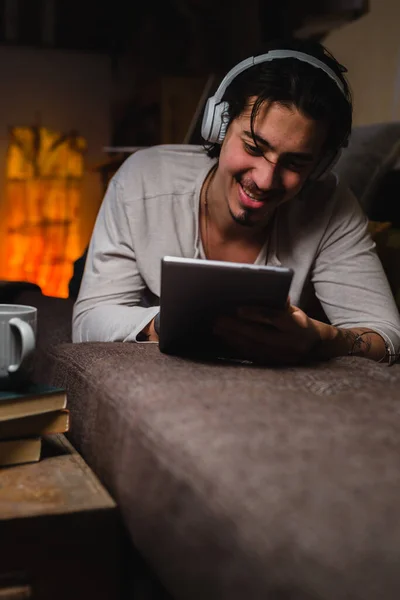 Kulaklıklı Bir Adam Odasındaki Kanepede Yatarken Dijital Tablet Kullanıyor Merhaba — Stok fotoğraf