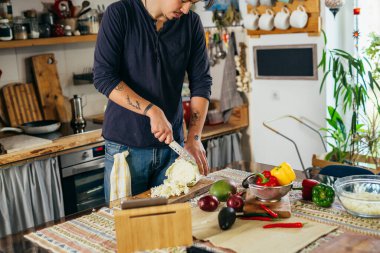 Adam evde sebze salatası hazırlıyor.