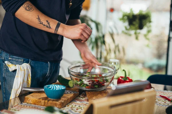 Adam mutfakta salata yapıyor.