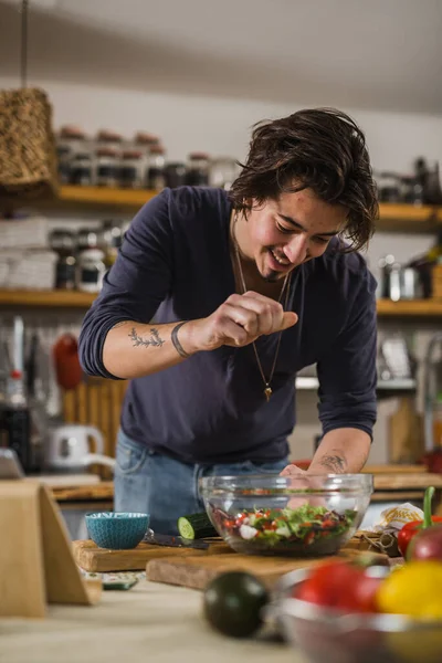 Adam mutfakta salata yapıyor.