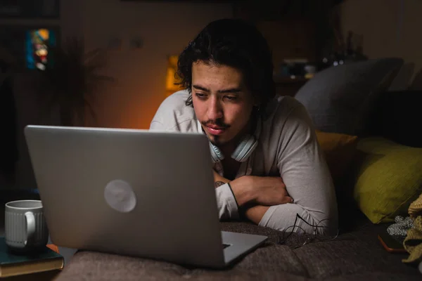 Liegt Hause Auf Einem Sofa Und Benutzt Einen Laptop — Stockfoto