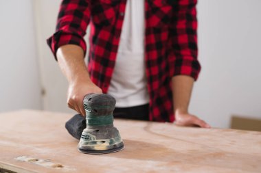 Adam eski kapıyı zımparalıyor. Yakın çekim.