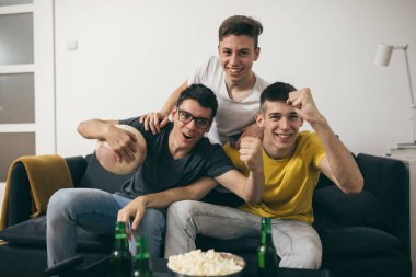 Arkadaşlar televizyonda maç izliyorlar.