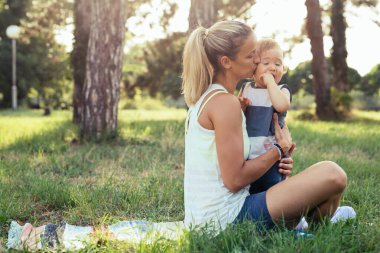 Anne oğluyla birlikte parkta egzersiz yapıyor.