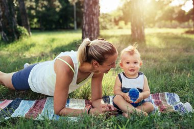 Anne oğluyla birlikte parkta egzersiz yapıyor.