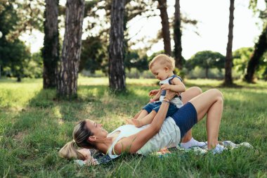 Anne oğluyla birlikte parkta egzersiz yapıyor.