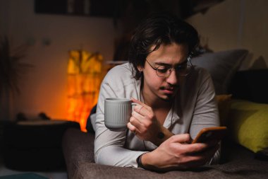 Evde cep telefonu kullanan adam.