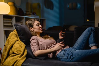 Evde cep telefonu kullanan bir kadın