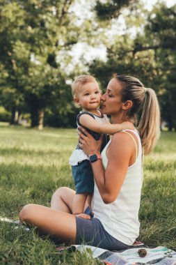 Anne ve oğlu halka açık parkta fiziksel egzersiz yapıyorlar.