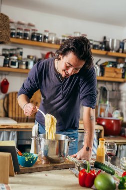 Adam evde spagetti hazırlıyor.