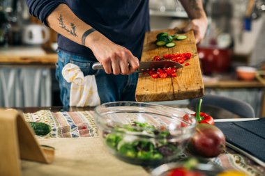 Adam mutfakta yemek hazırlıyor.