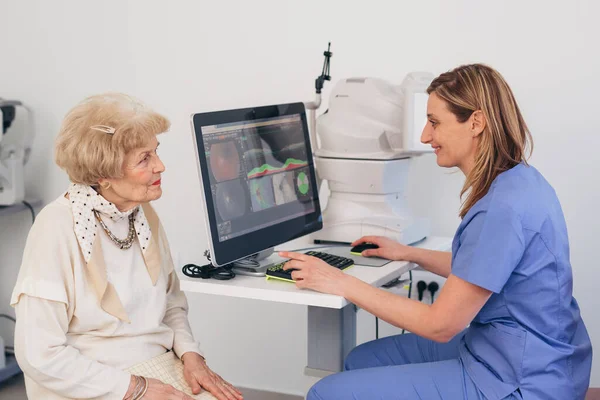 年上の女性は目の検査を受けてる デジタル網膜スキャナ — ストック写真