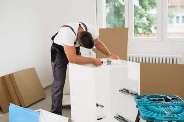 Evde tamirci mutfak dolabı var.