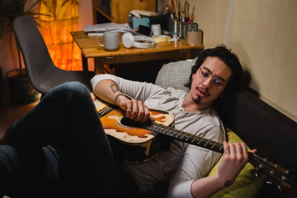 Homem Relaxando Sofá Casa Tocando Guitarra Ele Está Ouvindo Música — Fotografia de Stock