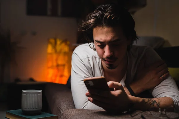 Mann Entspannt Sich Hause Auf Sofa Und Nutzt Smartphone — Stockfoto