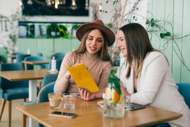 Restoranda menüye bakan kadınlar