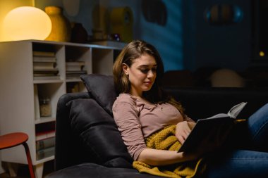 Evde kitap okuyan bir kadın. Akşam sahnesi