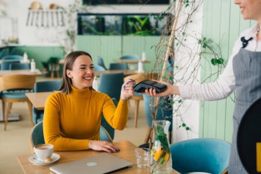 Kafede kredi veya banka kartıyla ödeme yapan kadın