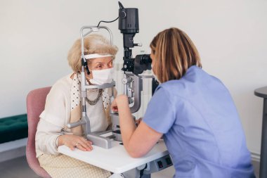 Yaşlı kadının göz muayenesi var. Coronavirus konsepti