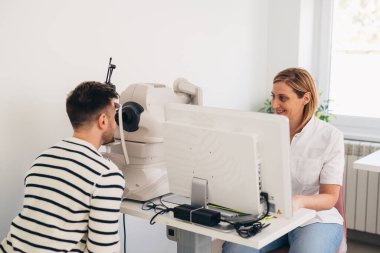 Adam klinikte gözlerini kontrol ediyor.