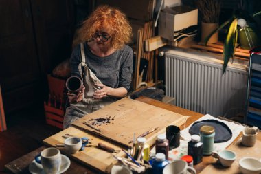 Kadın atölyesinde çömlek oyuyor.