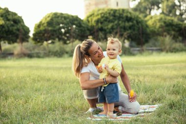 Anne ve oğlu dışarıda birlikte oynuyorlar.