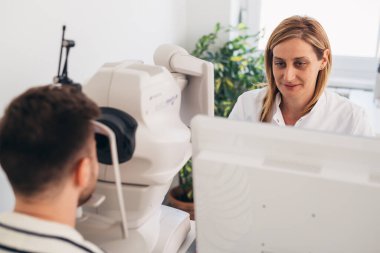 Adam klinikte gözlerini kontrol ediyor.