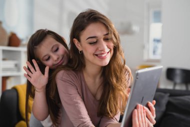 Anne ve kızı online sohbet için dijital tablet kullanıyorlar.