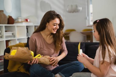 Kızı hediyesini annesine veriyor.