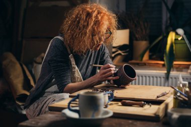 Atölyesinde çömlek oyan bir kadın.