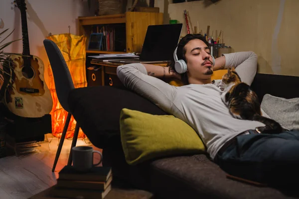 Mann Entspannt Sich Auf Einem Sofa Seinem Zimmer Und Hört — Stockfoto