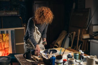 woman makes pottery in her workshop