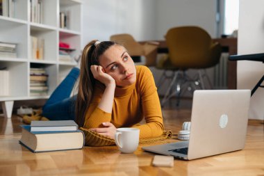 Kadın evinde dizüstü bilgisayar kullanıyor.