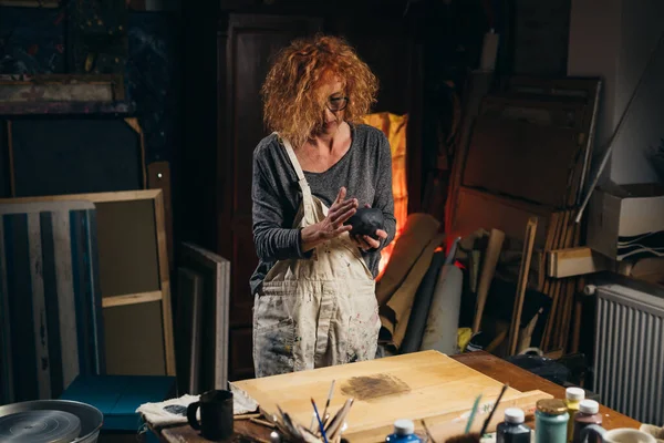 Kadın atölyesinde çömlek yapıyor.