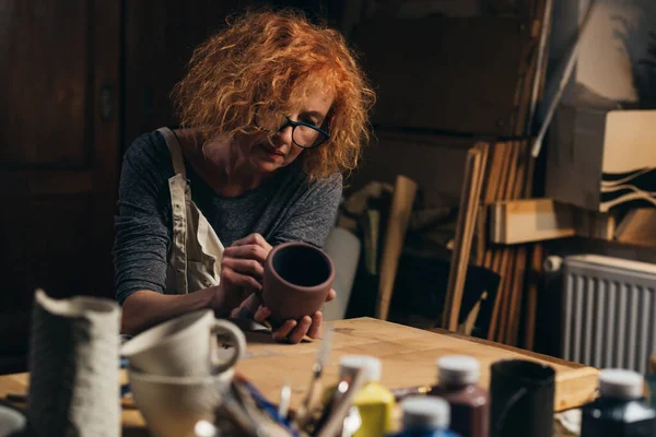 Atölyesinde çömlek oyan bir kadın.
