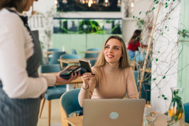 Faturayı ödeyen kadın akıllı telefonuyla iletişim kuramıyor.