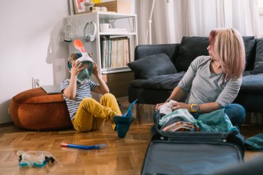 Bekar anne ve oğlu yaz tatili için valiz hazırlıyorlar.