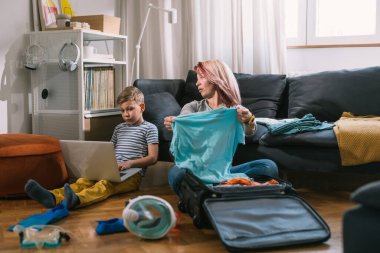 Bekar anne ve oğlu yaz tatili için valiz hazırlıyorlar.