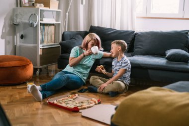 Bekar anne ve oğul evde eğleniyor, konuşuyor ve pizza yiyorlar.