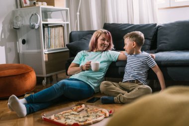 Bekar anne ve oğul evde eğleniyor, konuşuyor ve pizza yiyorlar.
