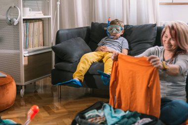 Anne ve oğlu yaz tatili için bavullarını hazırlarken harika vakit geçiriyorlar.