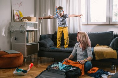 Anne ve oğlu yaz tatili için bavullarını hazırlarken harika vakit geçiriyorlar.