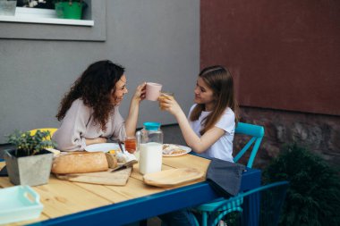 mother and daughter cheers while breakfast