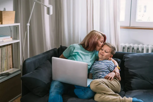 Mutter Küsst Ihren Sohn Während Sie Hause Auf Einem Sofa — Stockfoto