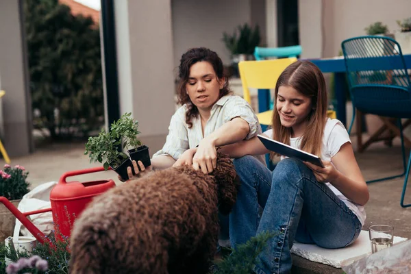 Caucasian Teenager Girl Gardening Her Latin Mother Backyard Using Digital — Stockfoto