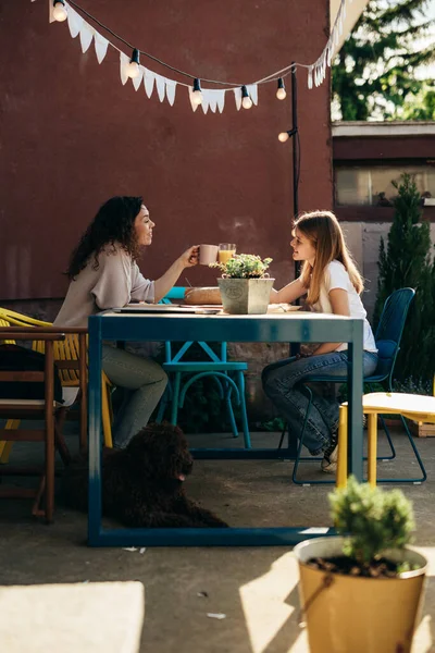 single mother and her daughter enjoying time together during breakfast in their backyard.